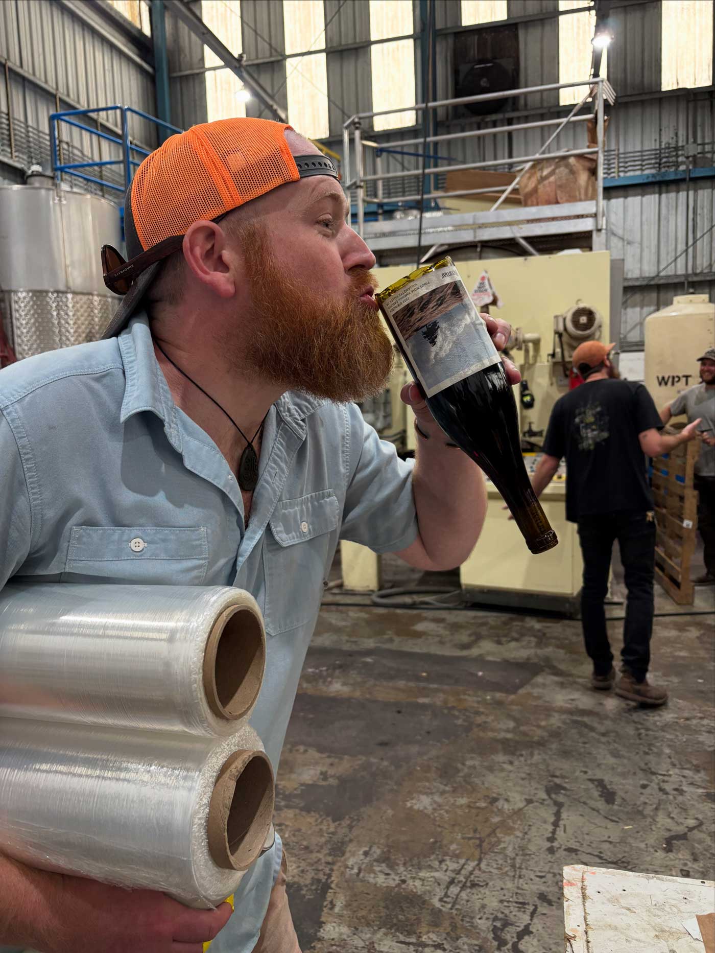 Ryan Kelly-Burnett photo sipping wine from a broken bottle